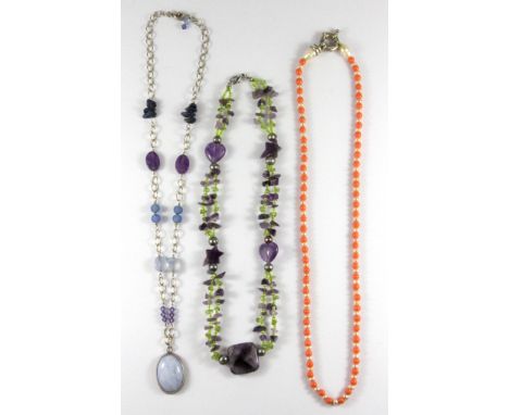 A silver and mixed stone necklace, an amethyst necklace and a cultured pearl and coral necklace.