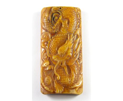 A Tibetan carved bone dragon amulet, H. 9cm.