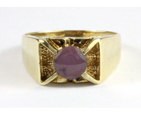 A gentleman's 9ct yellow gold ring set with a cabochon cut star sapphire, (W.5).