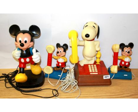 Three vintage Disney Mickey Mouse and Snoopy telephones.