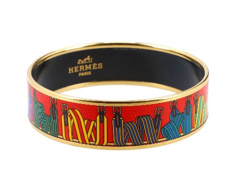 HERMÈS VINTAGE Armreif. Goldfarbene Umrandung. Mittig roter Grund mit Riemen-Motiven in Multicolor. Gebrauchsspuren vorhanden