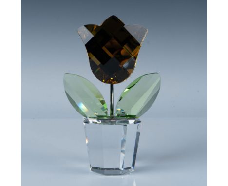 Features a vibrant yellow tulip with precision-cut facets, resting in a faceted clear crystal pot. The petals shimmer in gold