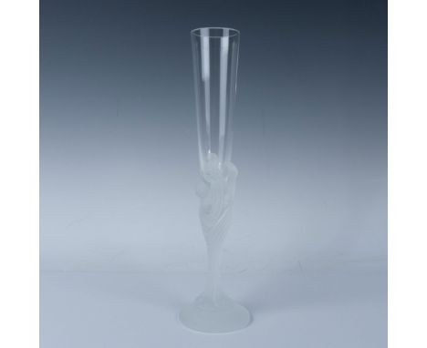 A clear glass with a frosted stem depicting the faces of seven women intertwined and flowing to the base. Erte engraved at ba