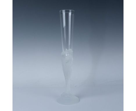 A clear glass with a frosted stem depicting the faces of seven women intertwined and flowing to the base. Erte engraved at ba