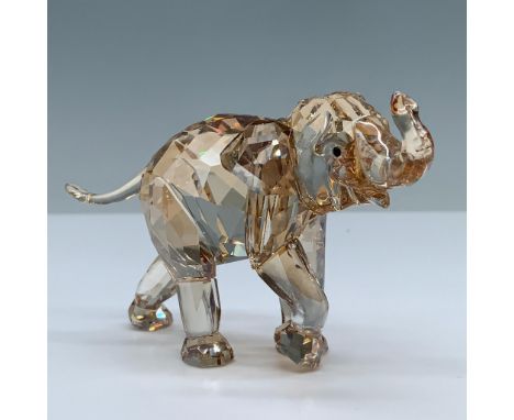 Lead crystal figural excellently crafted in a light sand color depicts an adorable elephant with its trunk raised. Swarovski 