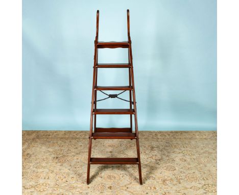 This impressive antique ladder features rich brown wood, six steps, upright grab handles, and is equipped with a patented met