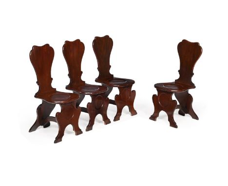A SET OF FOUR GEORGE II SOLID MAHOGANY HALL CHAIRSCIRCA 1750 Each of sgabello form, with escutcheon shaped backs, circular pa