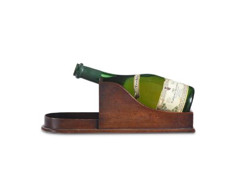 A LATE GEORGE III MAHOGANY WINE BOTTLE TILT OR CRADLE  CIRCA 1810 The cradle designed to hold the wine bottle at an angle all