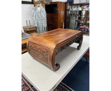 A Chinese hardwood coffee table, carved with the legs forming the scroll ends and the apron carved and pierced in the form of