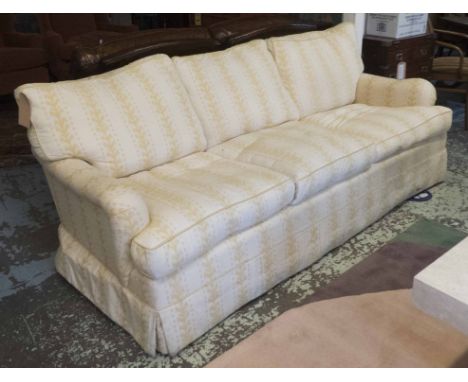 GEORGE SMITH SOFA, patterned yellow fabric with three seat and back cushions on turned legs and brass castors (upholstery wor