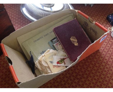 A box containing postcard, cigarette card albums and three volumes of Shakespeare.