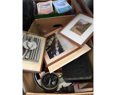A box of bric-a-brac including a barometer, framed pictures and other items.