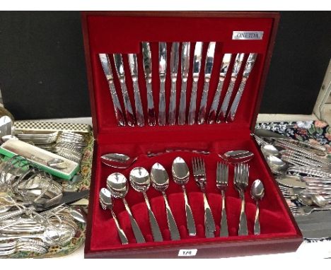 A shelf containing a quantity of silver plated and other cutlery including an Oneida canteen.