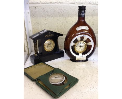 A small architectural slate cased mantle clock together with a Brandy bottle with inset Mercedes clock and an 8 day travellin