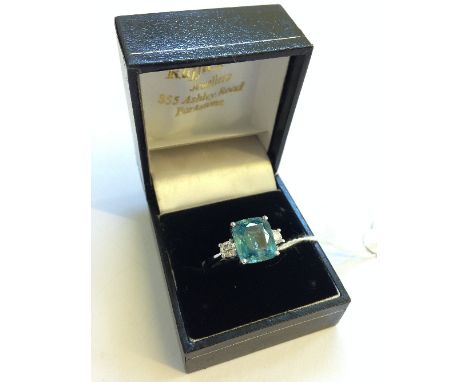 An 18 carat white gold natural blue zircon (8 carat) and diamond shoulder set ring.