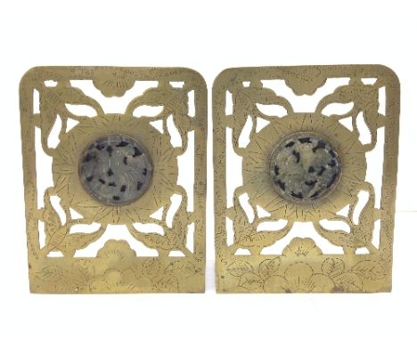 A pair of early 20th century Chinese brass bookends with inset carved jade rondells, decorated with birds.