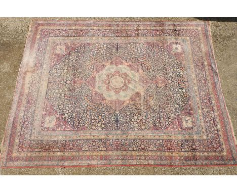 A 20th century Persian carpet, the central panel with a leafing bush on a blue ground surrounded by stylised foliate borders 
