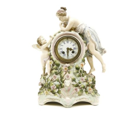 An early 20th century Continental porcelain clock, a lady, a cherub, and flower encrustation, striking on a bell, 39cm high