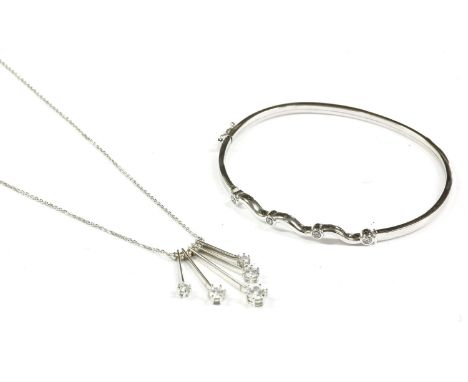 A 9ct white gold cubic zirconia hinge bangle, and a 9ct gold cubic zirconia fringe pendant on a chain, marked 375