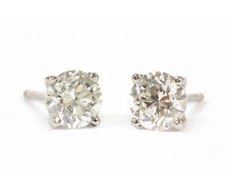 A pair of white gold single stone diamond stud earrings, with a brilliant cut diamond, four claw set to a plain wire collet, 