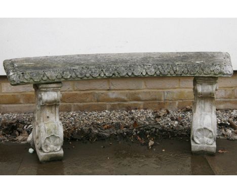 A cast stone curved bench, with gadrooned edge and shaped support (a/f), 120cm wide