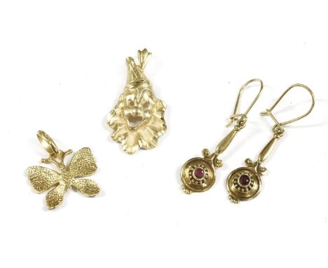 A Continental gold polychrome enamel butterfly pendant, marked 750, a gold clown mask pendant marked 14k, and a pair of Etrus