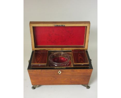 An early 19th Century Kingwood Tea Caddy of sarcophagus form containing two covered compartments and mixing bowl with brass r