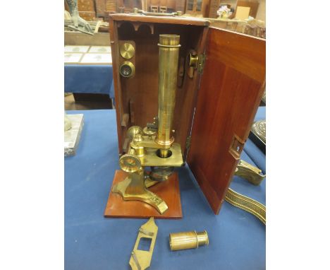 A Dolland, London Microscope in brass with spare lenses, in mahogany case, 14in H and a box of mounted glass slides