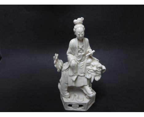 A Chinese blanc de chine porcelain Figure of Guanyin holding a scroll seated on a kylin on hexagonal base, 8 3/4in, small rep