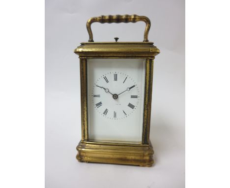 A late 19th Century brass cased Carriage Clock with white enamel dial, lever escapement, hour repeater, in original travellin