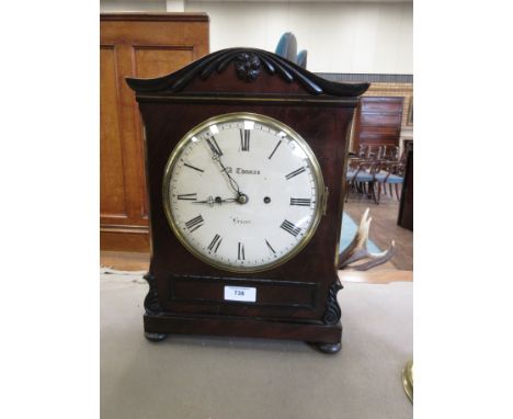 A Regency carved mahogany Bracket Clock the shaped top above an enamelled dial and tablet frieze on turned feet, fitted with 