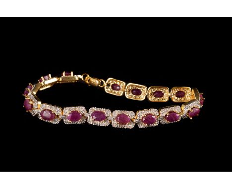 A silver gilt diamond and ruby bracelet, the multiple panels each having a single oval cut ruby surrounded by small illusion 