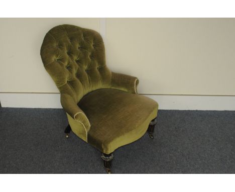 A Victorian button backed nursing chair,  with ebonised legs abd brass castors 