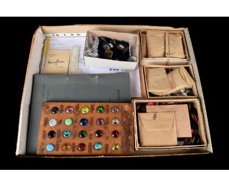 A collection of vintage buttons, in various materials and colours including a button gauge, tailors button sample book, and m