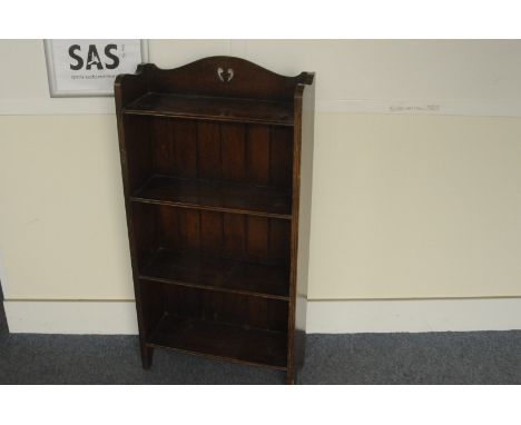 An Arts and Crafts oak free standing book shelf,  with shaped top and pierced design, 103cm high 