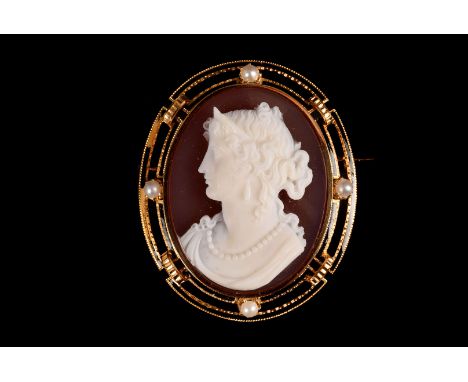A Victorian gold and sardonyx cameo brooch, the sardonyx cameo of a well dressed young lady set in a gold mount, with seed pe