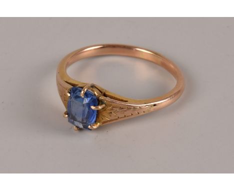 A vintage gold and sapphire solitaire ring, possibly a synthetic stone, in claw setting, with engraved to shoulders, unmarked