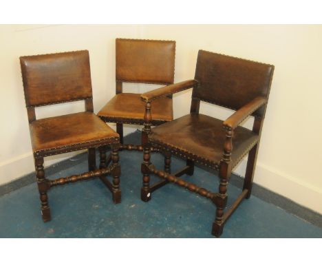 A set of six vintage Puriton style dining chairs, with brown leather seats and backs, comprising two carvers and four singles