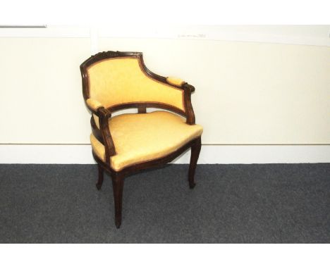 An Edwardian carved walnut and upholstered armchair, with light satin seat and back 