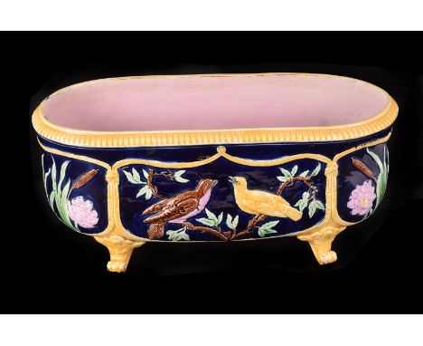 A Victorian pottery Majolica planter, possibly by Minton & George Jones, having bird amongst foliate decoration, on four scro