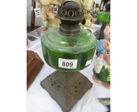 A Victorian oil lamp with green glass font