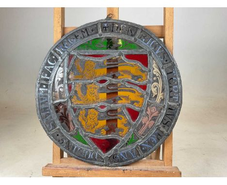 A circular 18th century stained glass panel, set with the three lions passant guardant, The Arms of the Plantagenet, with ins