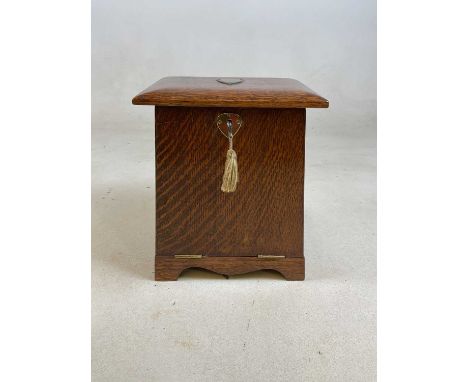 An oak Arts and Crafts desk top stationary box, with drop-down front, calendar from 1909 and glass inkwell, height 26cm, widt