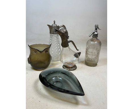 A vintage soda siphon labelled Leese &amp; Co Table waters, two claret jugs, one in the style of a duck, a glass owl bucket a