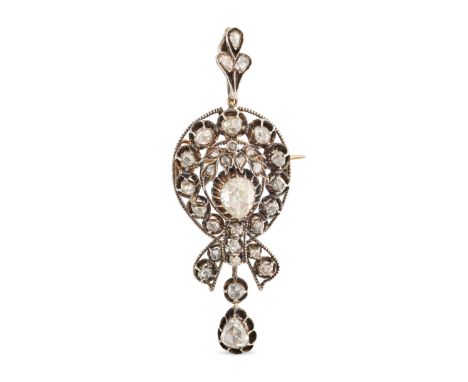 AN ANTIQUE DIAMOND PENDANT / BROOCH in yellow gold and silver, set with a principal pear shape rose cut diamond accented by f