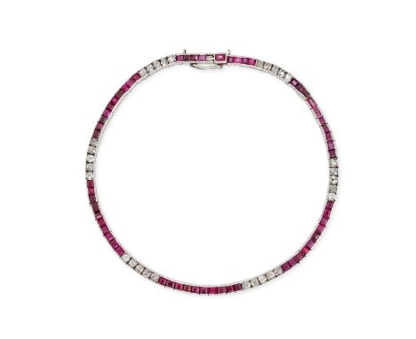 AN ART DECO RUBY AND DIAMOND LINE BRACELET in platinum, set with a row of calibre cut rubies and single cut diamonds, the rub