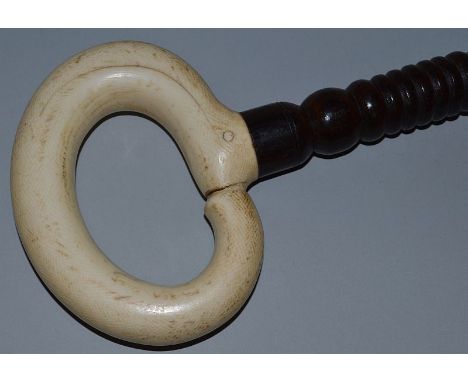 A HEAVY CARVED IVORY HANDLED WALKING STICK. 34ins long.