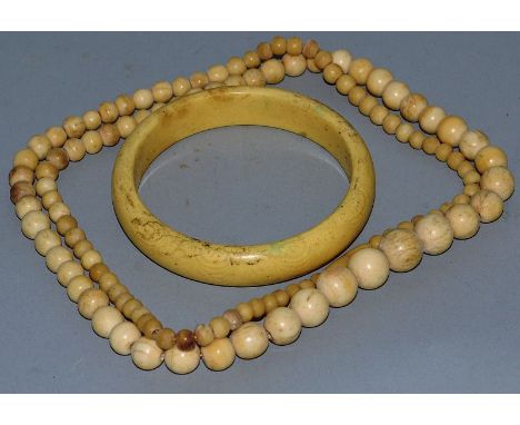 AN IVORY NECKLACE AND BANGLE.
