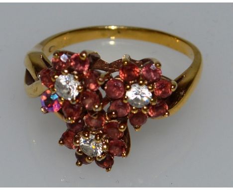 A DIAMOND AND RUBY FLORAL DRESS RING.