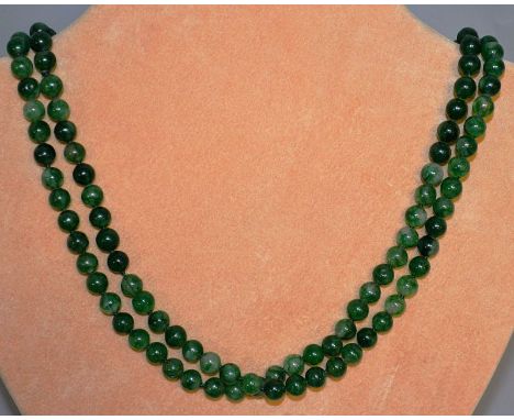 A STRING OF GREEN JADE BEADS. 48ins long.